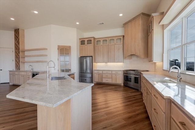 kitchen with a center island with sink, appliances with stainless steel finishes, sink, and light brown cabinets