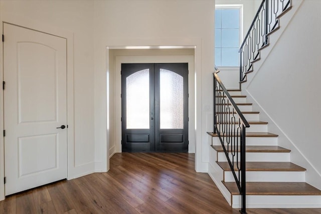 foyer entrance featuring french doors, baseboards, stairs, and wood finished floors