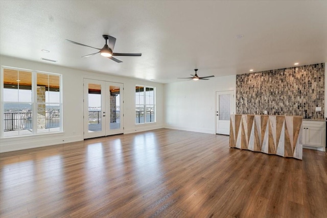 unfurnished living room featuring ceiling fan, dark wood-type flooring, and french doors