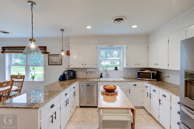 kitchen with backsplash, appliances with stainless steel finishes, a center island, and white cabinets