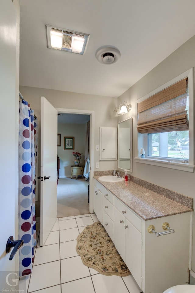 bathroom featuring tile floors and vanity with extensive cabinet space