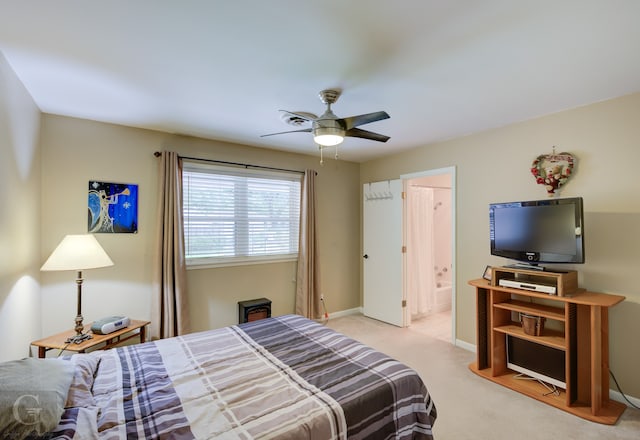 bedroom with light carpet, ensuite bathroom, and ceiling fan