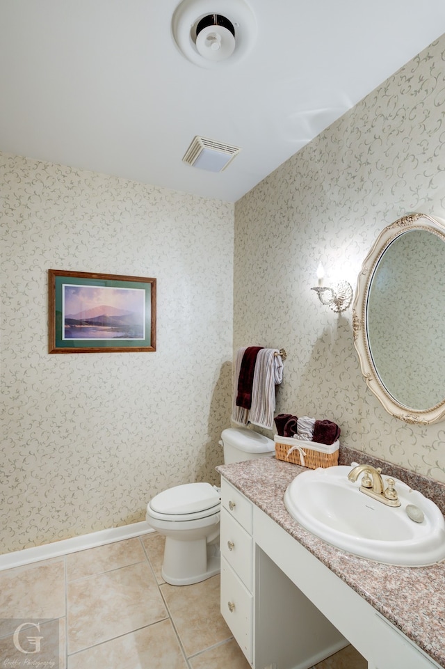 bathroom with tile floors, vanity, and toilet