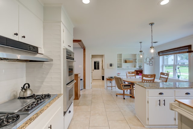 kitchen featuring decorative light fixtures, stainless steel appliances, tasteful backsplash, white cabinets, and light tile floors