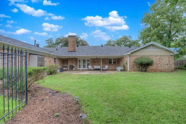 rear view of house with a patio and a lawn