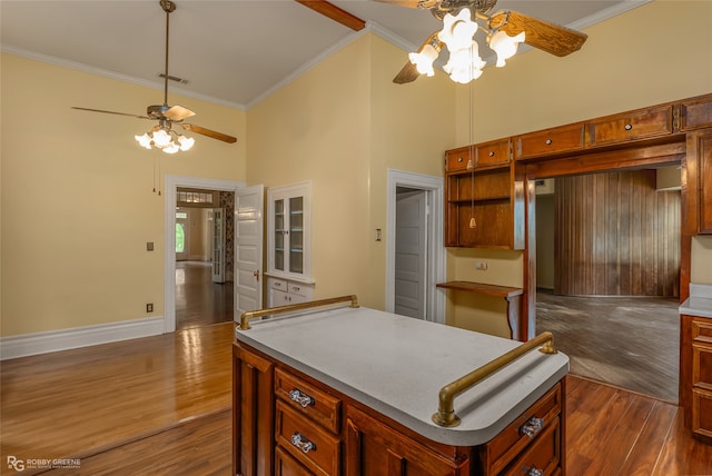 kitchen featuring crown molding, a kitchen island, dark colored carpet, and ceiling fan