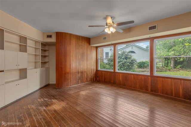 interior space with wood walls and hardwood / wood-style flooring