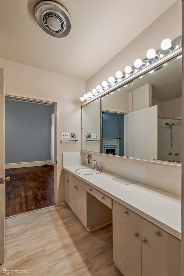 bathroom featuring hardwood / wood-style flooring and vanity with extensive cabinet space