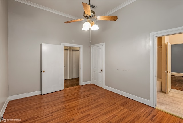 unfurnished bedroom with ceiling fan, hardwood / wood-style floors, and ornamental molding