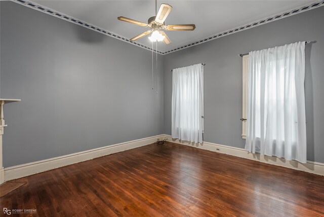 spare room featuring a healthy amount of sunlight, wood-type flooring, ornamental molding, and ceiling fan