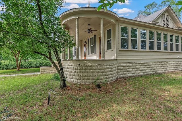 view of property exterior with ceiling fan and a lawn