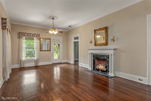 unfurnished living room featuring dark wood-type flooring, ceiling fan, a fireplace, and crown molding