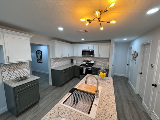 kitchen featuring white cabinetry, backsplash, dark hardwood / wood-style floors, and stainless steel appliances