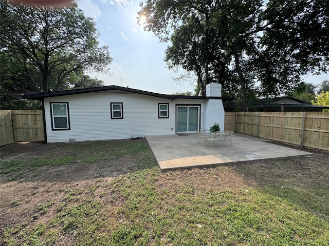 rear view of house featuring a lawn and a patio area