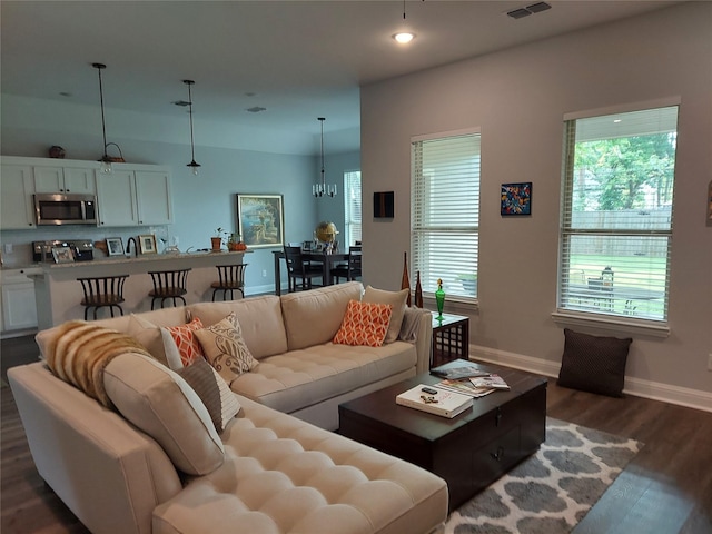 living room featuring dark hardwood / wood-style floors and a chandelier