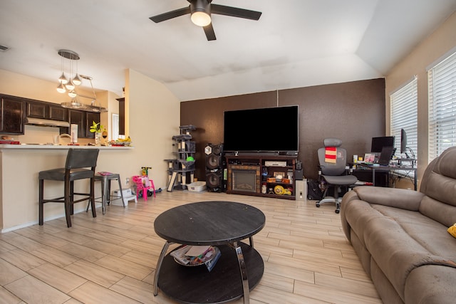 living room featuring light hardwood / wood-style flooring, vaulted ceiling, and ceiling fan with notable chandelier