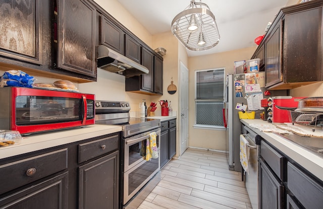 kitchen with wall chimney range hood, dark brown cabinets, and stainless steel appliances