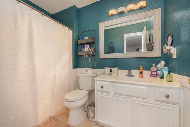 bathroom featuring tile flooring, vanity, and toilet