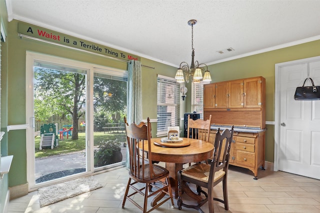 dining room with a notable chandelier, ornamental molding, and a textured ceiling