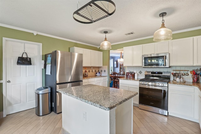 kitchen with a center island, decorative backsplash, light stone countertops, white cabinetry, and stainless steel appliances