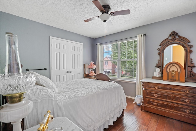 bedroom featuring ceiling fan, dark hardwood / wood-style flooring, a textured ceiling, and a closet