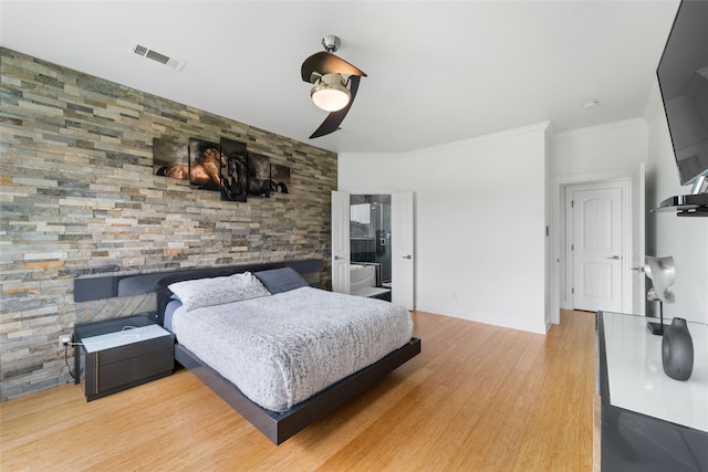 bedroom with light hardwood / wood-style floors, ensuite bathroom, ceiling fan, and crown molding