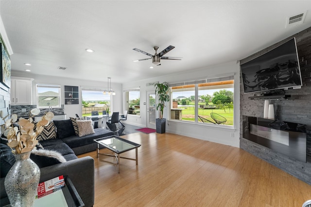 living room with ceiling fan and light hardwood / wood-style flooring