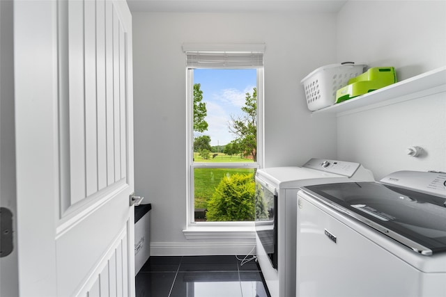 laundry room with separate washer and dryer and dark tile floors