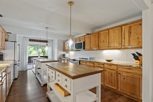 kitchen with a center island, dark hardwood / wood-style flooring, pendant lighting, stainless steel appliances, and decorative backsplash