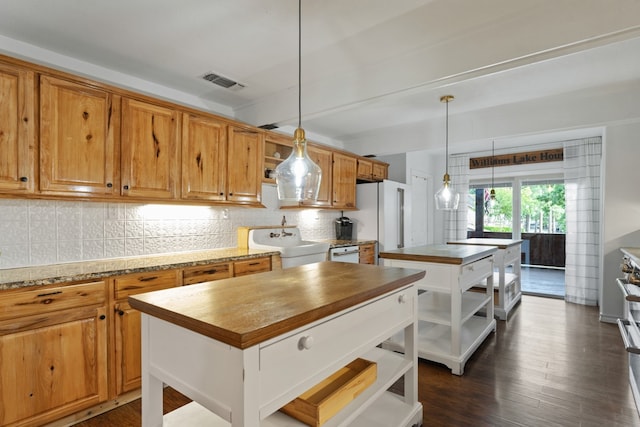 kitchen with tasteful backsplash, dark hardwood / wood-style flooring, a kitchen island, and white refrigerator