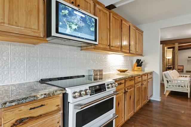 kitchen with backsplash, light stone counters, dark wood-type flooring, and appliances with stainless steel finishes