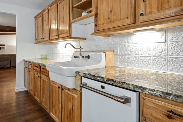 kitchen featuring dishwashing machine, dark stone counters, tasteful backsplash, and dark wood-type flooring