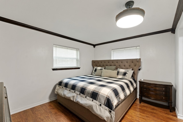 bedroom featuring multiple windows, crown molding, and wood-type flooring