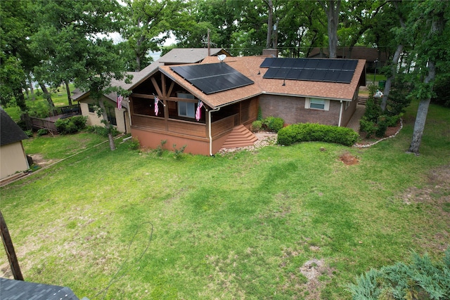 exterior space featuring solar panels and a front lawn