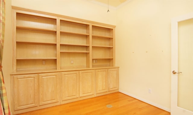 interior space featuring light wood-type flooring and crown molding