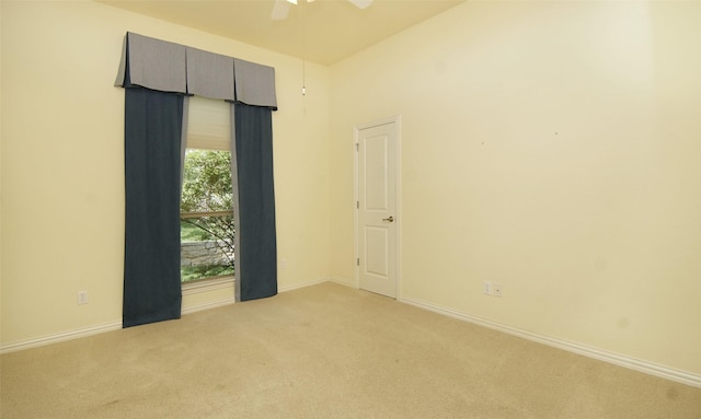 empty room featuring ceiling fan and light colored carpet