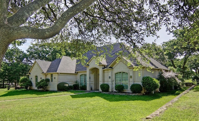 french country style house featuring a front lawn