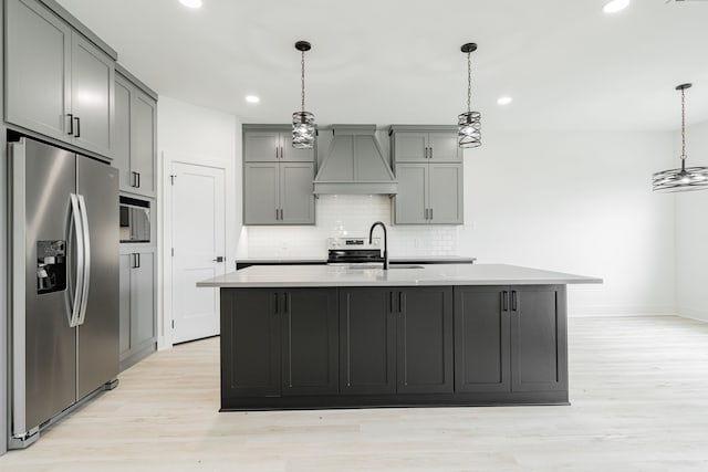 kitchen featuring light hardwood / wood-style floors, pendant lighting, premium range hood, backsplash, and stainless steel fridge with ice dispenser