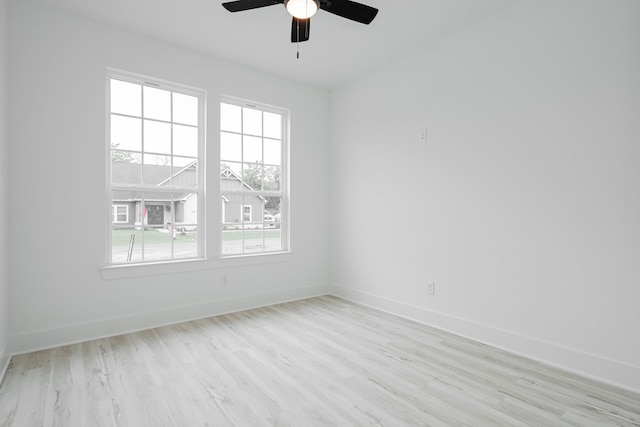 empty room with ceiling fan and light hardwood / wood-style floors