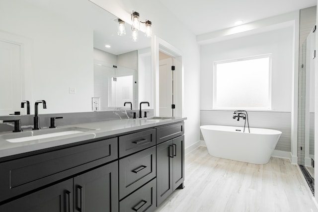 bathroom featuring dual vanity, independent shower and bath, tile walls, and hardwood / wood-style floors