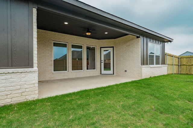 rear view of property with a patio area, a lawn, and ceiling fan