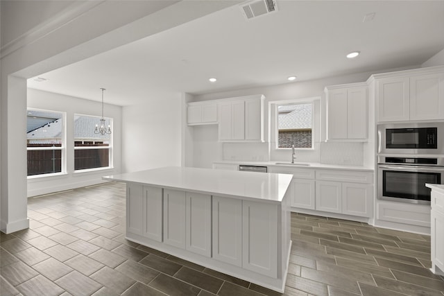 kitchen featuring appliances with stainless steel finishes, a center island, and white cabinetry