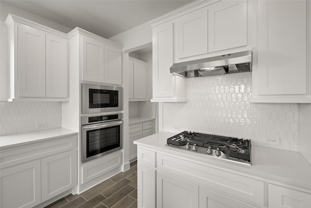 kitchen with white cabinets, decorative backsplash, and appliances with stainless steel finishes