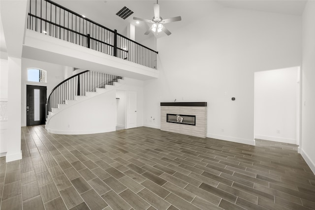 unfurnished living room with ceiling fan, high vaulted ceiling, and wood-type flooring