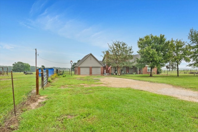 view of front of property featuring a front lawn, a garage, and a rural view