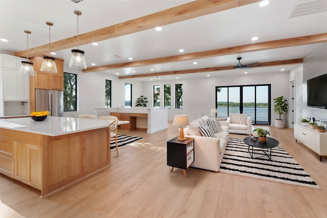 living room with ceiling fan, beamed ceiling, and light hardwood / wood-style flooring