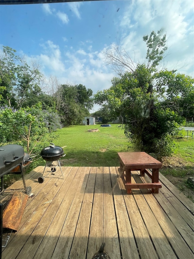 wooden terrace featuring a lawn