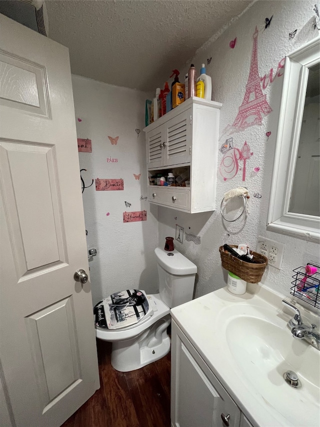 bathroom with toilet, hardwood / wood-style flooring, a textured ceiling, and large vanity