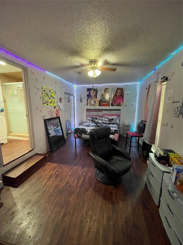 living room featuring hardwood / wood-style flooring, ceiling fan, and a textured ceiling