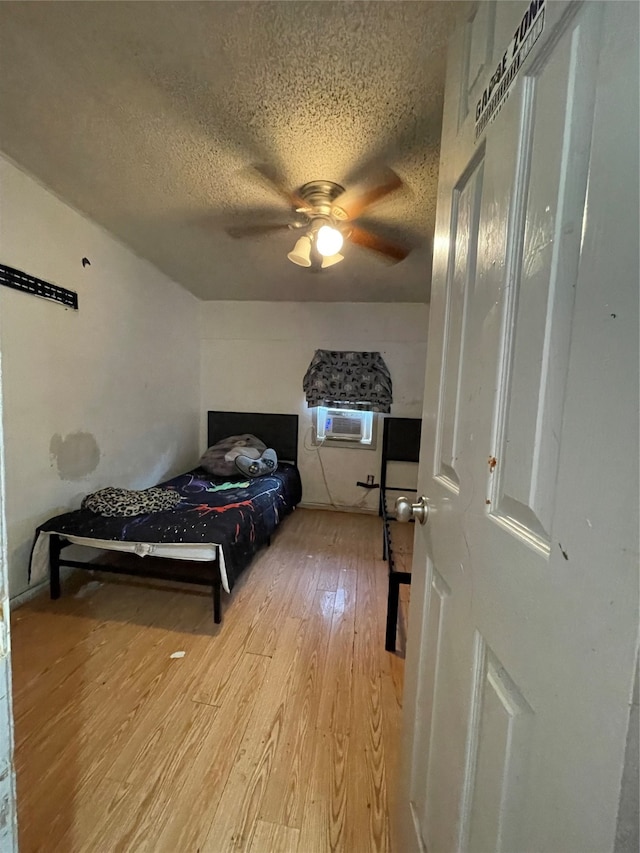 bedroom featuring a textured ceiling, ceiling fan, and light wood-type flooring